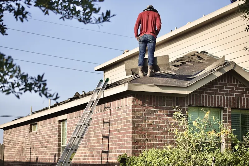 Professional roofer working on a residential roof in West University Place